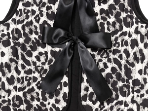 Detail of leopard print quilted vest with a sleek black satin bow tied on the front
