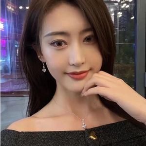 Elegant model wearing a silver heart pendant necklace and matching crystal earrings set