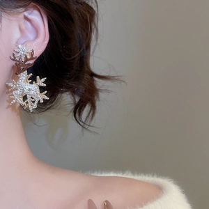 Detail of deer earring with snowflake and crystals on a model for Christmas