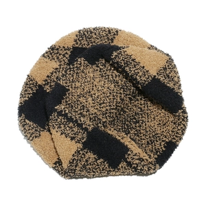 Detail of checkered plush knit beanie showing soft black and camel faux fur texture
