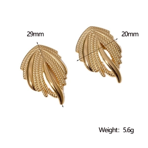 Macro detail of gold wing-shaped earrings with texture including size and weight specs