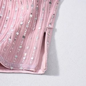 Détail de la fermeture éclair invisible et des paillettes argentées sur l'ensemble rose