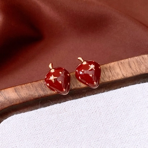 Macro detail of red enamel strawberry earrings with 18K gold plating and star zircons