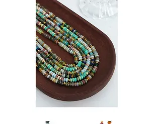Macro view of colorful abacus beads necklace with gold spacers on wooden tray