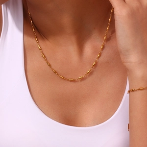 Detailed view of 18K gold plated olive bead necklace and bracelet set on a model