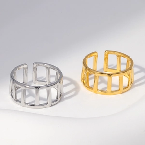 Detail of 18k gold and silver plated stainless steel rings with hollow grid design
