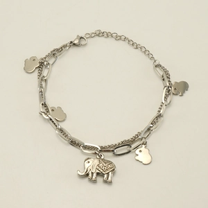 Macro detail of double-layered silver elephant bracelet with tiny charms and link chain
