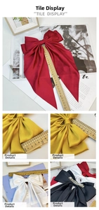 Close-up of large satin bow hair clip showing smooth texture and metal spring closure