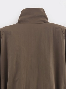 Detail of high neck collar and brown synthetic fabric texture on street style coat