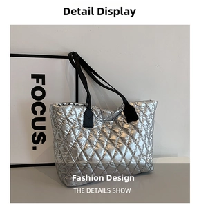 Detail of silver quilted tote bag with diamond stitching and black shoulder straps