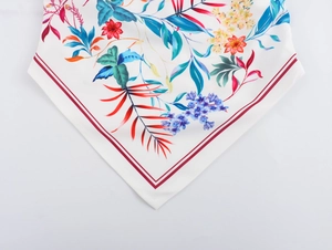 Detailed pattern showing tropical floral prints and red striped borders on white fabric