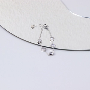 Detailed view of silver chain bracelet with round and square cubic zirconia in claw settings