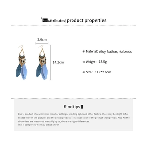Detail view of Bohemian feather earrings showing dimensions 14.2x2.6cm and blue beadwork