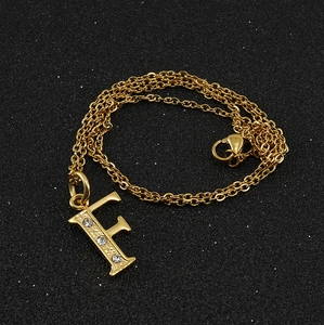Vue détaillée du pendentif lettre F plaqué or 18K avec trois strass incrustés et chaîne