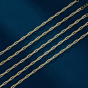 Macro detail of high-polish gold paperclip chain links with textured rectangular design