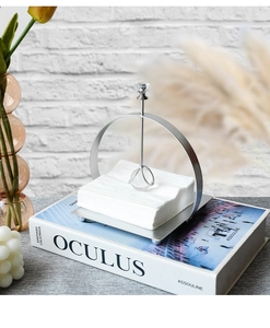Macro detail of silver iron napkin holder with crystal ball gravity arm on square tray
