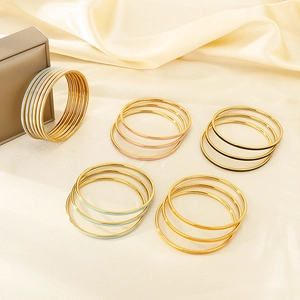 Close-up of minimalist colorful enamel stacked bracelets set on luxurious silk fabric