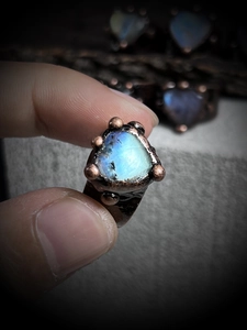 Macro shot of handmade copper ring with triangular glowing labradorite gemstone