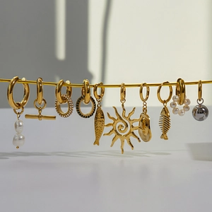 Boucles d'oreilles assorties en acier doré avec perles et breloques en présentation créative