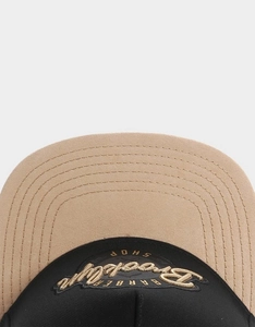 Detail of Brooklyn embroidery and premium stitching on khaki and black flat brim cap