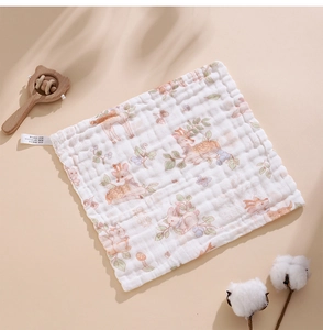 Detail of soft cotton gauze baby towel featuring watercolor deer and floral prints