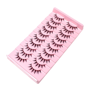 10 paar natuurlijke gekruiste kunstwimpers op een roze tray met witte achtergrond
