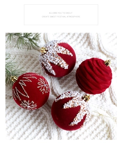 Detail of dark red flocked Christmas balls with pearls and glitter on white knit fabric