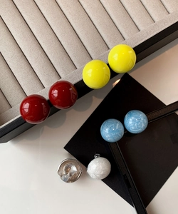 Détails de boucles d'oreilles boules minimalistes aux couleurs vives et finition brillante