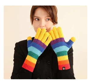Detail showing colorful rainbow striped knit gloves with a circular logo on the cuff