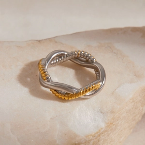 Detailed macro view of two-tone gold and silver twisted rope spiral ring on natural stone