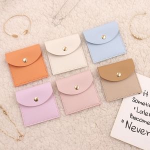 Macro shot of colorful microfiber jewelry pouches with gold snap buttons on plush fabric