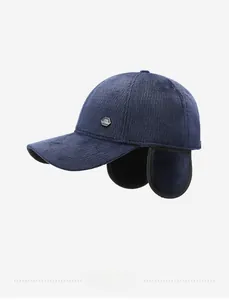 Detail view of navy blue corduroy winter baseball cap with protective ear flaps and metal logo