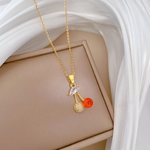 Detail of gold cherry pendant with red gemstone and sparkling rhinestones on necklace