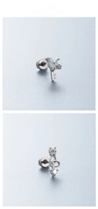 Dettaglio di piercing per elice con chiave a cuore e corona con zirconi colorati
