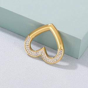 Polished gold heart pendant with sparkling rhinestones against a blue geometric block