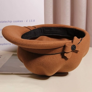 Detail of wool beret hat with a brown bow and elegant black crystal accents
