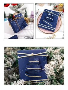 Detail of dark blue gift paper with gold foil flakes and festive ribbon decoration