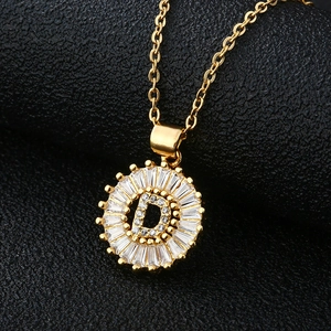 Gros plan du pendentif lettre D dorée avec zircons cubiques en serti baguette chic