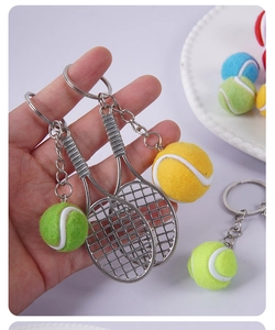 Macro shot of mini tennis racket keychain with realistic felt ball texture detail
