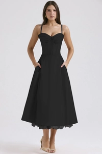 Detail of elegant black sundress showing slender straps and slim-fit waist tailoring