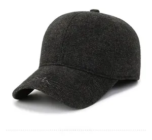 Detail of dark grey winter baseball cap with 1985 mountain metal badge and textured fabric