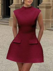 Detail eines ärmellosen Tweed-Kleides in Weinrot mit elegantem Stehkragen und Seitentaschen