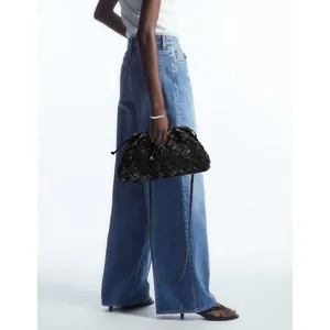 Fashionable black woven leather cloud bag with chain strap shown on a model