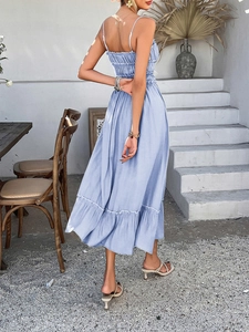 Detail of light blue sun dress featuring smocked back and tiered A-line skirt