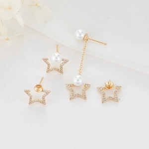 Star-shaped gold tassel earrings with zircon and pearls on white textured background