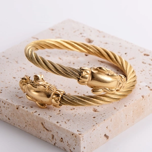 Adjustable golden stainless steel cable bangle with twin leopard head sculpture