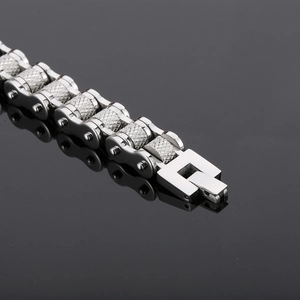 Macro shot of silver stainless steel bike chain bracelet with knurled industrial texture