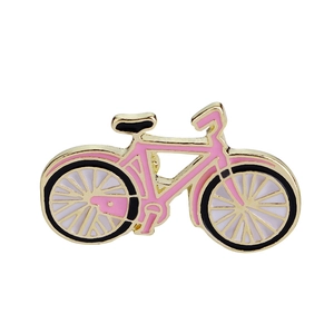 Dettaglio ravvicinato della spilla a bicicletta in smalto rosa con contorni in oro