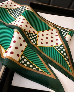 Detailed macro view of folded silk scarf with geometric polka dot patterns in elegant gift box