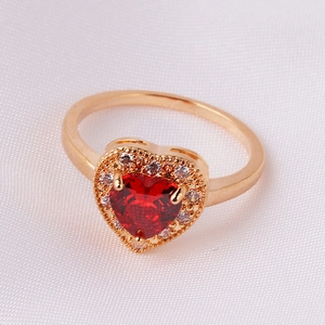 Macro shot of gold-plated heart-shaped red zircon ring with halo pave setting details